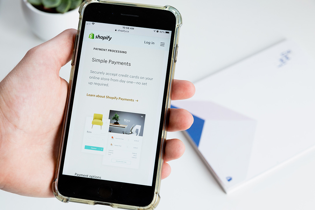 A smartphone displays Shopify
